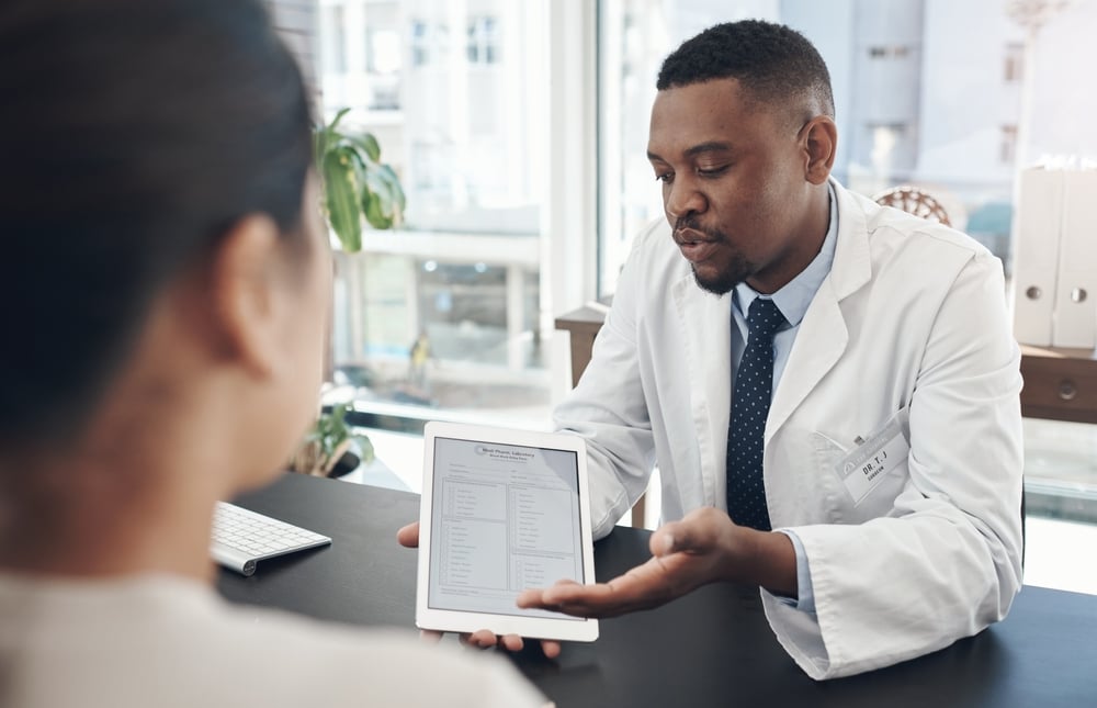 Shot of a young male doctor talking to a patient about a survey in an office.